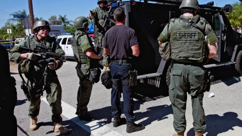 Los Angeles County Sheriff's department officers arrive at a standoff in the Sylmar section of Los Angeles on Monday, April 4, 2011. Police blasted tear gas into a home and traded gunfire Monday with a man believed to have shot and critically wounded an officer during a nightlong standoff. The man remained barricaded in the Sylmar home for more than 12 hours as police and Los Angeles County sheriff's officers in armored vests and helmets surrounded the house. (AP Photo/Nick Ut)