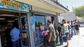 People line up outside Bluebird Liquors in Hawthorne, Calif., to buy lottery tickets Friday afternoon, July 8, 2016. The Mega Millions jackpot for Friday's drawing has soared to over $500 million. (AP Photo/Nick Ut)