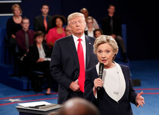 La candidata presidencial demócrata Hillary Clinton habla mientras el candidato presidencial republicano Donald Trump escucha durante el segundo debate presidencial en la Universidad de Washington en St. Louis, el domingo 9 de octubre de 2016.