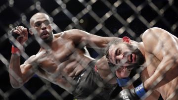Jon Jones, left, and Dominick Reyes, right, during a light heavyweight mixed martial arts bout at UFC 247 Saturday, Feb. 8, 2020, in Houston. (AP Photo/Michael Wyke)