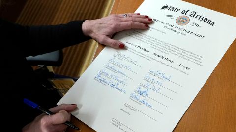 Un miembro del Colegio Electoral de Arizona, firma el certificado de boleta electoral presidencial de Arizona el lunes 14 de diciembre de 2020 en Phoenix.