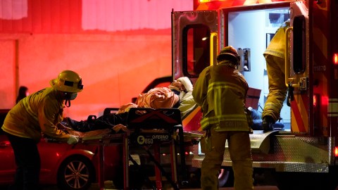 Los Angeles Fire Department paramedics move an injured person into an ambulance after a car crashed against a parked pizza oven trailer on Sunset Boulevard in Los Angeles on Saturday, Dec. 26, 2020. Two people in were transported to a hospital, according to firefighters. (AP Photo/Damian Dovarganes)