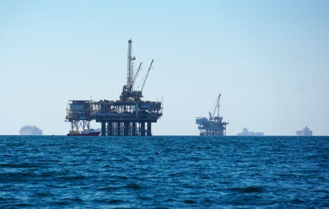 FILE - In this Oct. 5, 2021, file photo, cargo vessels are seen anchored offshore, sharing space with oil platforms, before heading into the Los Angeles-Long Beach port. A group of environmental organizations is demanding the Biden administration suspend and cancel oil and gas leases in federal waters off the California coast after a recent crude oil spill. The Center for Biological Diversity and about three dozen organizations sent a petition Wednesday, Oct. 20, 2021, to the Department of the Interior, arguing it has the authority to end these leases. (AP Photo/Eugene Garcia, File)