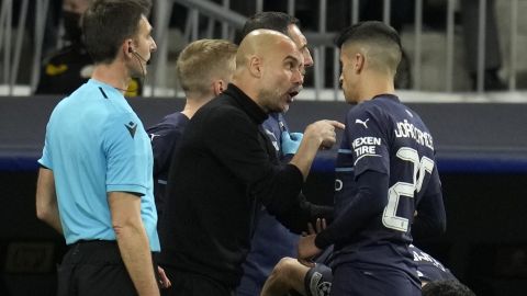 Manchester City's head coach Pep Guardiola, center, gives instructions to Manchester City's Joao Cancelo during the Champions League semi final, second leg soccer match between Real Madrid and Manchester City at the Santiago Bernabeu stadium in Madrid, Spain, Wednesday, May 4, 2022. (AP Photo/Manu Fernandez)