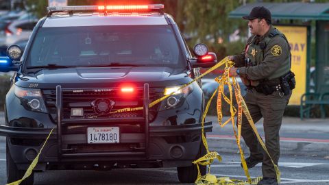 A Orange County Sheriff deputy removes yellow tape from a vehicle outside the Geneva Presbyterian Church in Laguna Woods, Calif., Sunday, May 15, 2022, after a fatal shooting. (AP Photo/Damian Dovarganes)