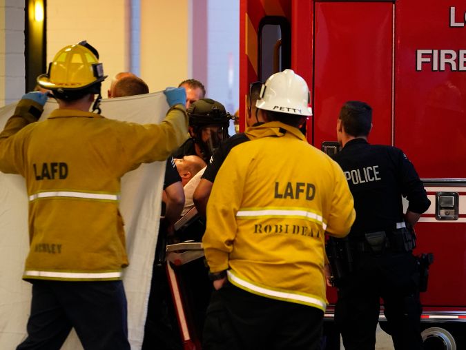 A suspect who stabbed multiple people and barricaded himself inside the Encino Hospital Medical Center is transported into a waiting ambulance after being extracted from the hospital in Encino, Calif., late Friday, June 3, 2022. (AP Photo/Damian Dovarganes)