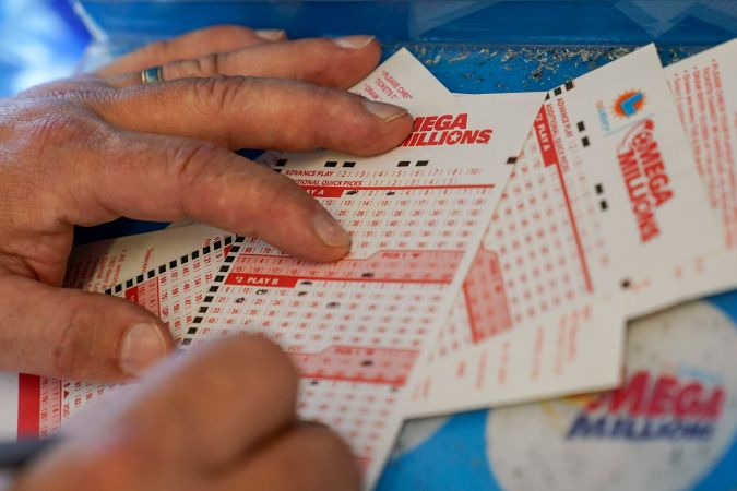 FILE - In this July 26, 2022 file photo, Gordon Midvale fills out a lottery ticket inside a 7-Eleven store in Oakland, Calif. The Mega Millions lottery jackpot has topped $1 billion — only the fourth time a lottery game has reached such heights. (AP Photo/Godofredo A. Vásquez, File)