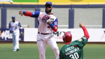 Dominican Republic's baseman Robinson Cano, left, releases the ball to first after tagging out Mexico's baseman Roberto Valenzuela to complete a double play during a Caribbean Series baseball game in Caracas, Venezuela, Thursday, Feb. 2, 2023. (AP Photo/Fernando Llano)