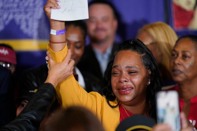 Anneisha Williams, right, who works at a Jack in the Box restaurant in Southern California celebrates as she holds up the bill signed by California Gov. Gavin Newsom at the SEIU Local 721 in Los Angeles, on Thursday, Sept. 28, 2023. California fast food workers will be paid at least $20 per hour next year under the new law signed by Newsom. (AP Photo/Damian Dovarganes)