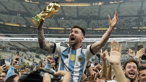 FILE - Argentina's Lionel Messi celebrates with the trophy in front of the fans after winning the World Cup final soccer match between Argentina and France at the Lusail Stadium in Lusail, Qatar, Sunday, Dec. 18, 2022. Lionel Messi has been named FIFA’s best men’s player after moving to Inter Miami and leading the team to a little-known Leagues Cup title, all while single-handedly elevating soccer’s relevance in the United States. The 36-year-old Argentina star on Monday was selected over Kylian Mbappe and Erling Haaland — the same pair he beat for his eighth Ballon d’Or award last October. (AP Photo/Martin Meissner, File)