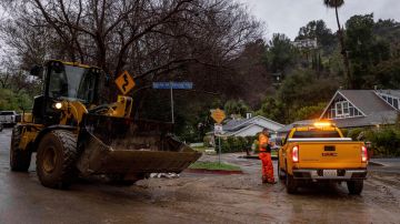 Workers clear storm debris from a Tuesday, Feb. 6, 2024, in the Sherman Oaks area of Los Angeles. (AP Photo/Ethan Swope)