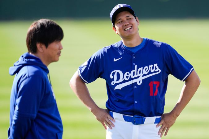 Los Angeles Dodgers designated hitter Shohei Ohtani (17) and his interpreter Ippei Mizuhara, left, participate in spring training baseball workouts at Camelback Ranch in Phoenix, Sunday, Feb. 18, 2024. (AP Photo/Ashley Landis)