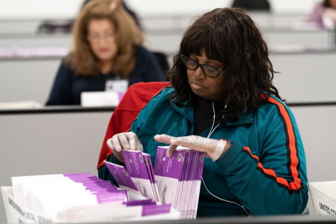 Una trabajadora electoral verifica las firmas en las boletas enviadas por correo en el Centro de Procesamiento de Boletas del condado de Los Ángeles, el 29 de febrero de 2024.