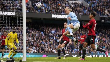 Manchester City's Erling Haaland, centre tries to score during an English Premier League soccer match between Manchester City and Manchester United at the Etihad Stadium in Manchester, England, Sunday, March 3, 2024. (AP Photo/Dave Thompson)