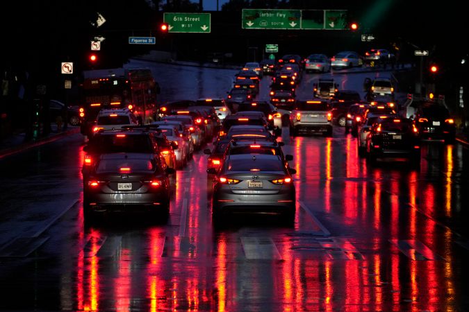 Commuters line up in traffic to enter the I-110 Harbor freeway under the rain downtown in Los Angeles, Wednesday, March 6, 2024. (AP Photo/Damian Dovarganes)