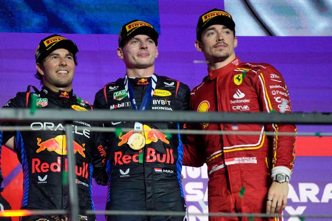 Sergio "Checo" Pérez posando junto a su compañero de equipo Max Verstappen y el piloto de Ferrari, Charles Leclerc.