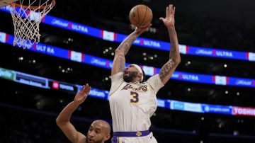 Los Angeles Lakers forward Anthony Davis (3) goes to the basket against Minnesota Timberwolves guard Jordan McLaughlin, left, during the first half of an NBA basketball game in Los Angeles, Sunday, March 10, 2024. (AP Photo/Eric Thayer)
