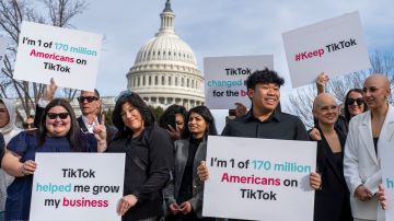 Devotees of TikTok cheer their support to passing motorists at the Capitol in Washington, before the House passed a bill that would lead to a nationwide ban of the popular video app if its China-based owner doesn't sell, Wednesday, March 13, 2024. Lawmakers contend the app's owner, ByteDance, is beholden to the Chinese government, which could demand access to the data of TikTok's consumers in the U.S. (AP Photo/J. Scott Applewhite)