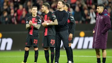 Leverkusen's head coach Xabi Alonso, centre, embraces Exequiel Palacios at the end of the Europa League round of sixteen, second leg, soccer match between Bayer Leverkusen and Qarabag FK at the BayArena in Leverkusen, Germany, Thursday, March 14, 2024. (AP Photo/Martin Meissner)