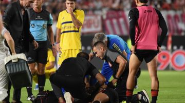 Estudiantes de La Plata's Javier Altamirano is assisted by members of his team during an Argentine soccer league match against Boca Juniors in La Plata, Argentina, Sunday, March 17, 2024. The match was suspended after Altamirano was taken off the field in ambulance.(AP Photo/Ignacio Amiconi )