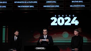 Competitions Director of Conmebol Frederico Nantes, center, holds a paper with the name of Argentina's Rosario Central during the Copa Libertadores draw in Luque, Paraguay, Monday, March 18, 2024. (AP Photo/Jorge Saenz)