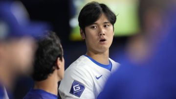 Los Angeles Dodgers designated hitter Shohei Ohtani, right, stands in the dugout with Dodgers manager of performance operations and interpreter Will Ireton during the first inning of a baseball game against the San Diego Padres at the Gocheok Sky Dome in Seoul, South Korea Thursday, March 21, 2024, in Seoul, South Korea. (AP Photo/Lee Jin-man)