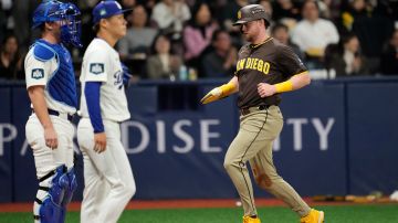 San Diego Padres' Jake Cronenworth, right, scores on a sacrifice fly by Ha-Seong Kim as Los Angeles Dodgers catcher Will Smith, left, and starting pitcher Yoshinobu Yamamoto stand by during the first inning of a baseball game at the Gocheok Sky Dome in Seoul, South Korea Thursday, March 21, 2024, in Seoul, South Korea. (AP Photo/Lee Jin-man)