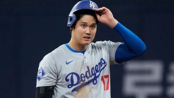 Los Angeles Dodgers designated hitter Shohei Ohtani takes his helmet off after making it to first on a fielder's choice during the fifth inning of an opening day baseball game against the San Diego Padres at the Gocheok Sky Dome in Seoul, South Korea Wednesday, March 20, 2024, in Seoul, South Korea. (AP Photo/Ahn Young-joon)