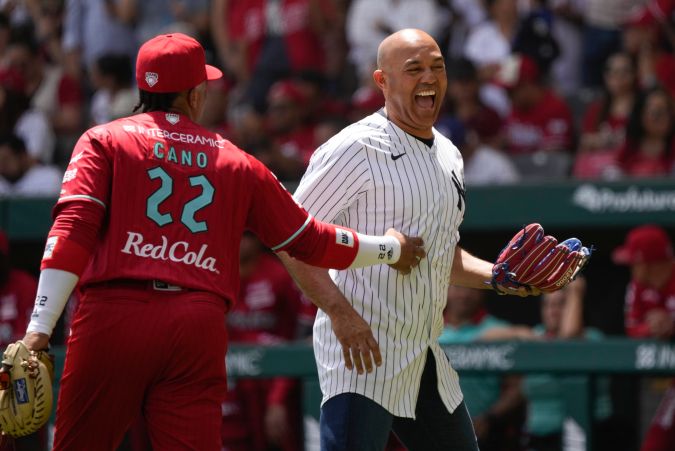 Diablos Rojos' Robinson Cano, left, and former New York Yankees' pitcher Mariano Rivera, of Panama, during a baseball exhibition game at Alfredo Harp Helu Stadium in Mexico City, Sunday, March 24, 2024. (AP Photo/Fernando Llano)