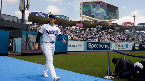 Shohei Ohtani recorre una alfombra azul a través del campo al ser presentado durante la ceremonia inaugural de los Dodgers en su estadio.