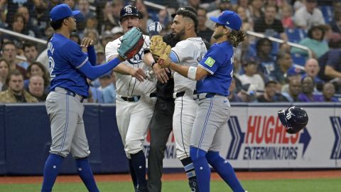 Tampa Bay Rays third base coach Brady Williams, center left, and Toronto Blue Jays shortstop Bo Bichette, right, try to break up a confrontation between Tampa Bay's Jose Caballero, center right, and Toronto Blue Jays reliever Genesis Cabrera, left, after Cabrera pushed Caballero during the seventh inning of a baseball game, Saturday, March 30, 2024, in St. Petersburg, Fla. (AP Photo/Steve Nesius)