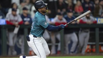 Seattle Mariners' Julio Rodriguez watches his RBI single against the Boston Red Sox during the 10th inning of a baseball game Saturday, March 30, 2024, in Seattle. The Mariners won 4-3 in 10 innings. (AP Photo/Stephen Brashear)