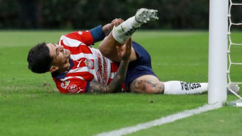 Víctor Guzmán, de Chivas, se duele sobre el césped tras una jugada.