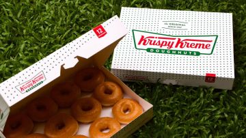Dos cajas de Krispy Kreme en un exuberante jardín verde. La empresa anunció que comenzará a vender sus donas en McDonald’s.