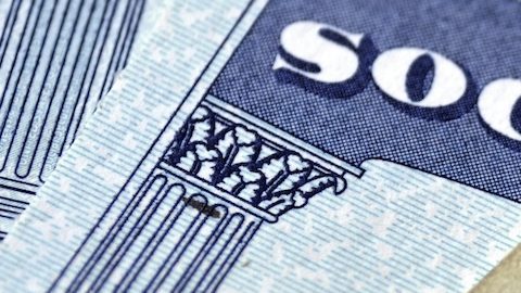 Varias Tarjetas de Seguridad Social y dinero en efectivo que simbolizan la seguridad financiera de las pensiones de jubilación.