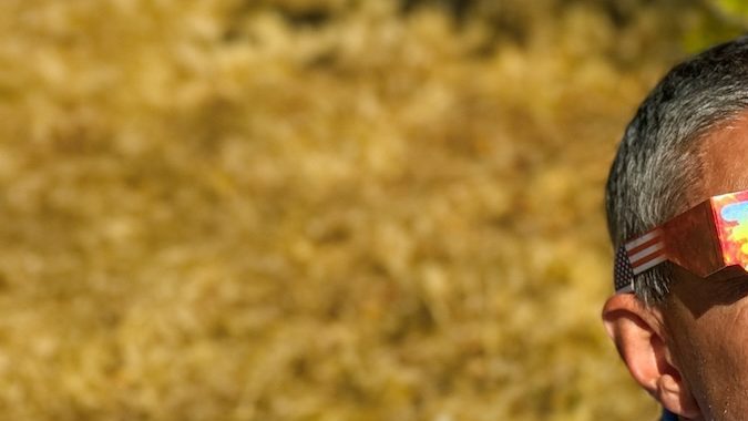 Padre e hija, familia viendo el eclipse solar con gafas especiales en un parque.