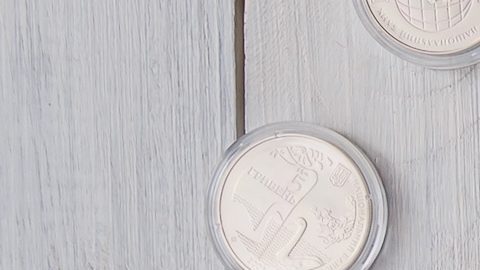 Álbum con monedas y monedas en cápsulas sobre la mesa.