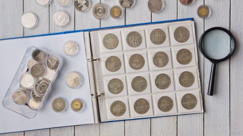 Álbum con monedas y monedas en cápsulas sobre la mesa.