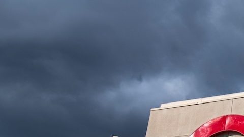 Vista en ángulo de una tienda Target, frente a un cielo azul y nubes.