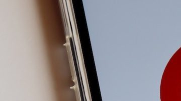 Logotipo de Target en la pantalla del teléfono inteligente y vasos Target y bolsa de compras al fondo