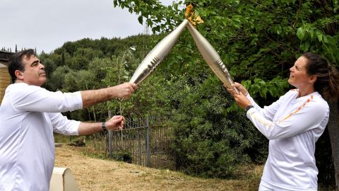 Ancient Olympia (Greece), 16/04/2024.- Second torchbearer France Swimming Olympic champion Laure Manaudou passes the Olympic Flame to the Vice-President of the European Commission Margaritis Schinas during the Lighting Ceremony of the Olympic Flame for the Paris 2024 Olympic Games, in Archaia Olympia, Greece, 16 April 2024. The Summer Olympics Games will be held in Paris, France from 26 July to 11 August 2024. (Francia, Grecia) EFE/EPA/VASSILIS PSOMAS