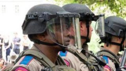 Una estudiante mira fijamente a una hilera de policías estatales de Texas durante las protestas.