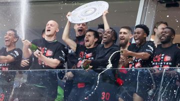 Los jugadores del Bayer Leverkusen levantando el título de campeón de la Bundesliga delante de sus aficionados que invadieron el campo para festejar con su equipo el histórico campeonato logrado.