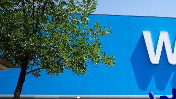 Carrito de compras en un estacionamiento frente a la entrada principal de un Walmart.