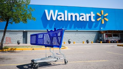 Carrito de compras en un estacionamiento frente a la entrada principal de un Walmart.