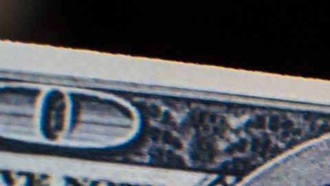 Un billete de cien dólares está en llamas.