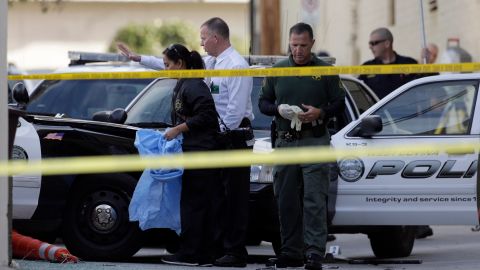 Los Angeles County Sheriff's homicide detectives help police investigate an officer-involved shooting that happened at the end of a car pursuit in Glendale, Calif., on Monday, March 14, 2016. The driver hit speeds topping 100 mph during the pursuit that was broadcast live on news stations Sunday night. Police shot and killed a suspect who stole a West Covina patrol car, partially seen left, and led officers on an hour-long chase across Southern California freeways that ended when an officer in an SUV slammed into the stolen vehicle in the alley, pinning the suspect inside as he gunned the engine, trying to escape again. Police opened fire, killing the 45-year-old man at the scene, authorities said. (AP Photo/Nick Ut)