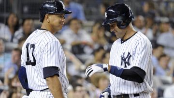 New York Yankees' Derek Jeter, right, celebrates with Alex Rodriguez after Jeter scored during the seventh inning of a baseball game against the Chicago White Sox Wednesday, Sept. 4, 2013, at Yankee Stadium in New York. (AP Photo/Bill Kostroun)