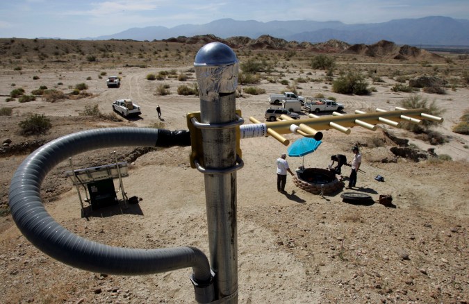 FILE - This March 11, 2009 file photo shows an antenna to send data stands on a rise above an earthquake monitoring well, right, powered by a solar electric panel, lower left, as scientists from the U.S. Geological Survey set up an earthquake monitoring station on the San Andreas Fault in a desert canyon near Thermal, Calif. The nation's first statewide quake warning system will debut Thursday, Oct. 17, 2019, coinciding with the 30th anniversary of the Loma Prieta earthquake that ravaged the San Francisco Bay area on Oct. 17, 1989, as well as the annual Great Shakeout safety drill. (AP Photo/Reed Saxon, File)