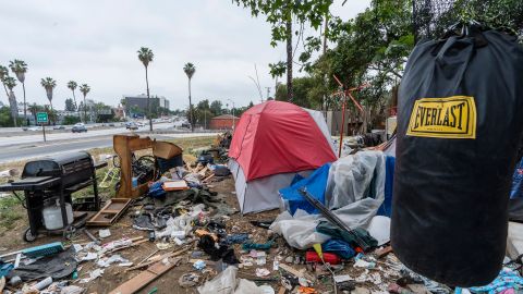 FILE - In this Tuesday, May 11, 2021, file photo, a trashed punching bag is left at a homeless encampment is seen on the side of the CA-101 highway in Echo Park neighborhood in Los Angeles. The City Council has passed a sweeping anti-camping measure to remove widespread homeless encampments that have become an eyesore across the city. California is home to more than a quarter of the nation's homeless people, according to federal data, and it has reached a crisis point in many cities. (AP Photo/Damian Dovarganes, File)